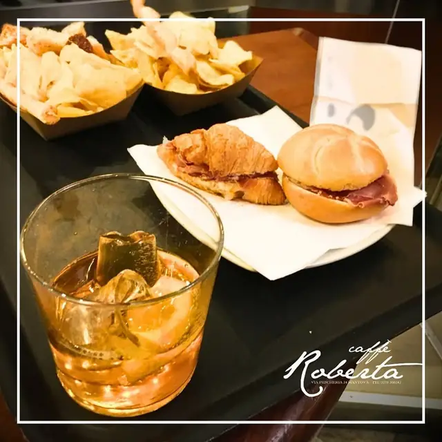 Cocktail con croissant salato e panino al prosciutto per l'aperitivo